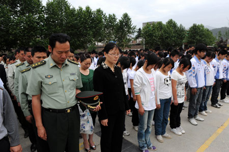 Representatives mourn for the victims in the fatal May 12, 2008 Wenchuan earthquake during a ceremony marking the first anniversary of the quake in Qingchuan County, southwest China's Sichuan Province, on May 12, 2009.