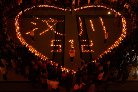 Students gather around candles displaying 'Wenchuan' and '512' during an activity to mourn for the victims of the May 12, 2008 Wenchuan earthquake, at the Harbin Institute of Technology in Harbin, capital of northeast China's Heilongjiang Province, on May 12, 2009, the anniversary of the fatal Wenchuan earthquake.