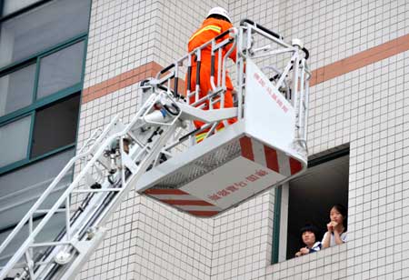 Students take part in a quake rescue drill at Jingcheng Experimental School in Hangzhou, capital of Zhejiang Province in east China, on May 12, 2009, China's first National Disaster Prevention and Reduction Day on the occasion of the first anniversary of the May 12, 2008 Wenchuan earthquake.