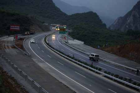 Vehicles run on the newly finished highway connecting Yingxiu Town and Dujiangyan City, both hard-hit by last year's massive earthquake in southwest China's Sichuan Province, on May 11, 2009.