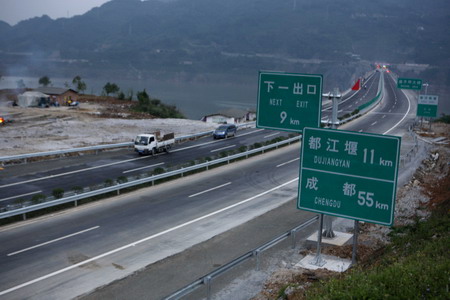 Vehicles run on the newly finished highway connecting Yingxiu Town and Dujiangyan City, both hard-hit by last year's massive earthquake in southwest China's Sichuan Province, on May 11, 2009.