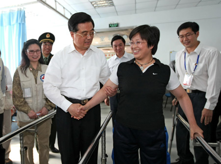 Chinese President Hu Jintao helps a handicapped woman caused by the quake of last year in a rehabilitation center in Deyang, southwest China's Sichuan Province. Hu Jintao and vice Premier Li Keqiang visited the reconstruction projects in the quake-hit places in southwest China's Sichuan Province on May 11 and May 12, 2009. 