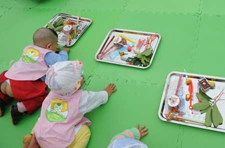 Babies grab lots at a school in Shifang City, southwest China's Sichuan Province, on May 13, 2009.