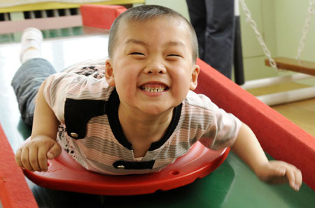 A student plays in a special education nursery school in Shenyang, on May 13, 2009. The nursery school started in 1994, and has taught some 1000 disabled students during the past 15 years. 