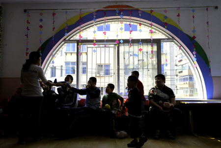 Students play with their teacher in a special education nursery school in Shenyang, on May 13, 2009. The nursery school started in 1994, and has taught some 1000 disabled students during the past 15 years. 