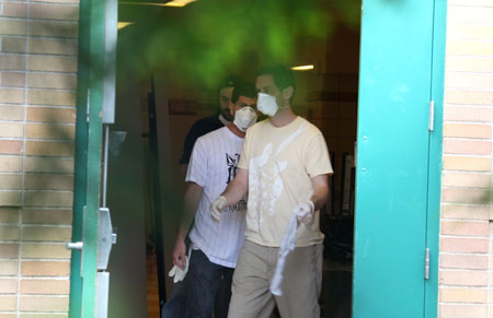 Workers wearing masks disinfect the IS 5 school building in Elmhurst of Queens borough of New York, the US, on May 15, 2009. Three New York City public schools in its Queens borough, IS 238 in Jamaica, PS 16 in Corona and IS 5 in Elmhurst, were closed on Friday due to reports of many children with flu-like symptoms.