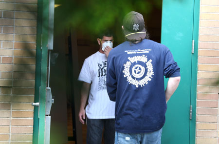 A man wears a mask while standing inside the IS 5 school in Elmhurst of Queens borough of New York, the US, on May 15, 2009. Three New York City public schools in its Queens borough, IS 238 in Jamaica, PS 16 in Corona and IS 5 in Elmhurst, were closed on Friday due to reports of many children with flu-like symptoms.