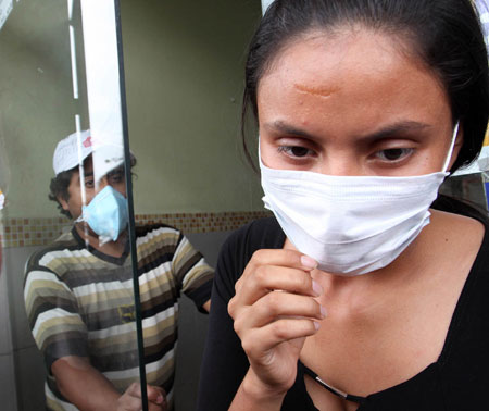 A woman leaves hospital with a mask to prevent the A/H1N1 flu in Guayaquil, Ecuador, on May 15, 2009. Health authorities on Friday confirmed the first case of A/H1N1 flu identified on a child of twelve years old. 