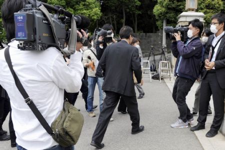 Journalists follow a man walking to a high school where the confirmed A/H1N1 flu patient studies in Kobe city, Japan, on May 16, 2009. Japan's first domestic case of A/H1N1 flu was confirmed on Saturday. The patient is a 17-year-old male high school student in Kobe city, who has no records of overseas travel, according to the Ministry of Health, Labor and Welfare. 