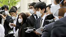 Journalists with facemasks work at the high school where the confirmed A/H1N1 patient studies in Kobe city, Japan, on May 16, 2009. Japan's first domestic case of A/H1N1 flu was confirmed on Saturday. The patient is a 17-year-old male high school student in Kobe city, who has no records of overseas travel, according to the Ministry of Health, Labor and Welfare.