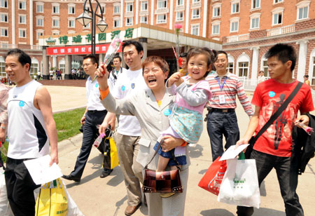 People leave a hotel in Chengdu, capital of southwest China's Sichuan Province, on May 16, 2009. More than 120 people quarantined at the hotel for having close contacts with A/H1N1 flu patient surnamed Bao were allowed to leave the hotel on Saturday after they were lifted out of medical observation.