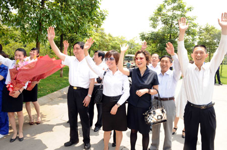 Relatives and colleagues wave to the people who are lifted quarantine at a hotel in Chengdu, capital of southwest China's Sichuan Province, on May 16, 2009. 