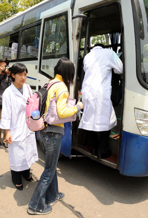 People board the vehicle to leave a hotel in Chengdu, capital of southwest China's Sichuan Province, May 16, 2009.