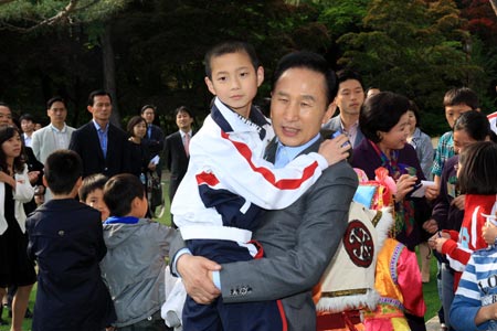 South Korean President Lee Myung-bak holds Chinese pupil Wei Yuehao at the presidential palace Cheong Wa Dae in Seoul on May 17, 2009. Lee Myung-bak on Sunday met with a delegation of 20 youngsters from southwest China's Sichuan Province, which was seriously hit in the Wenchuan earthquake on May 12, 2008. 