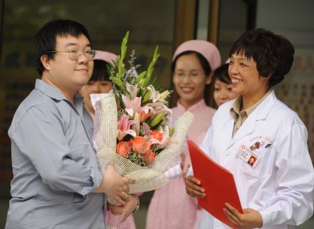 The A/H1N1 patient surnamed Bao (L) is about to leave the hospital in Chengdu, capital of southwest China's Sichuan Province, on May 17, 2009. The patient, who was China's first patient in the case of A/H1N1 flu, was discharged from hospital Sunday after recovery, local authorities said.