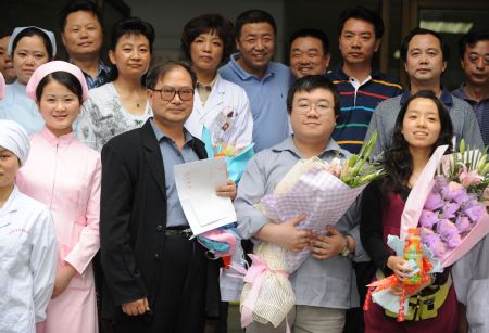 The A/H1N1 patient surnamed Bao (2nd R, Front) poses for a photo with his girlfriend (1st R, Front), his father (3rd R, Front) and medical staff in Chengdu, capital of southwest China's Sichuan Province, on May 17, 2009. The patient, who was China's first patient in the case of A/H1N1 flu, was discharged from hospital Sunday after recovery, local authorities said.