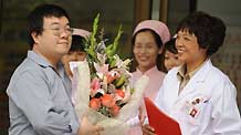 The A/H1N1 patient surnamed Bao (L) is about to leave the hospital in Chengdu, capital of southwest China's Sichuan Province, on May 17, 2009.