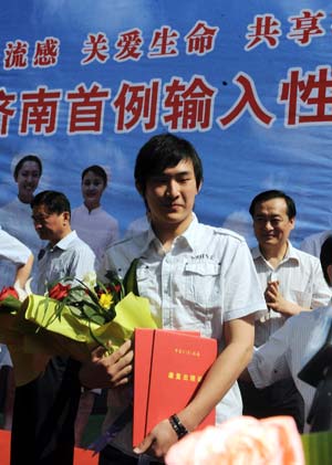 Lu (C), China's second confirmed A/H1N1 influenza patient, reacts as he leaves a hospital in Jinan, capital of east China's Shandong Province, on May 19, 2009. China's second confirmed A/H1N1 influenza patient was discharged from hospital at 9:00 AM on Tuesday after eight days of treatment.