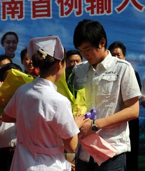 Lu (R), China's second confirmed A/H1N1 influenza patient, receives a bouquet from a nurse as he leaves a hospital in Jinan, capital of east China's Shandong Province, on May 19, 2009. China's second confirmed A/H1N1 influenza patient was discharged from hospital at 9:00 AM on Tuesday after eight days of treatment. 