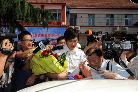 Lu (C), China's second confirmed A/H1N1 influenza patient, is surrounded by reporters as he leaves a hospital in Jinan, capital of east China's Shandong Province, on May 19, 2009. China's second confirmed A/H1N1 influenza patient was discharged from hospital at 9:00 AM on Tuesday after eight days of treatment.