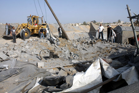 Palestinian men inspect the damaged smuggling tunnel linking the southern Gaza Strip town of Rafah with Egypt following an overnight Israeli air strike in Gaza Strip, on May 20, 2009. Israeli warplanes on Tuesday night carried out a series of airstrikes on several targets in the Palestinian Gaza Strip, wounding one person and causing severe damages to two buildings, medics and witnesses said.