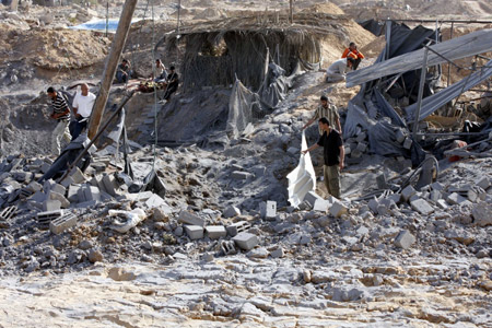 Palestinian men inspect the damaged smuggling tunnel linking the southern Gaza Strip town of Rafah with Egypt following an overnight Israeli air strike in Gaza Strip, on May 20, 2009. 