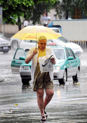 An old man holding an umbrella walks in the rain in Guangzhou, capital of south China's Guangdong Province, on May 20, 2009. A rainstorm hit Guangzhou on Wednesday and affected drainage system and traffic. 