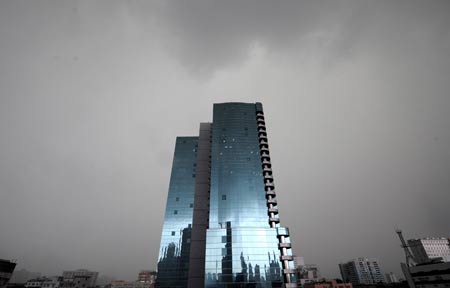 Buildings are shrouded by dark clouds before the rain in Guangzhou, capital of south China's Guangdong Province, on May 20, 2009. A rainstorm hit Guangzhou on Wednesday and affected drainage system and traffic.