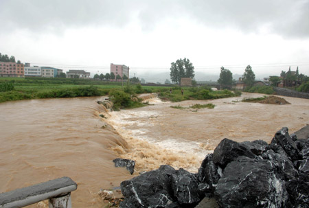 Flood water runs down the farmland near Chenzhou City, south China&apos;s Hunan Province, on May 20, 2009 after heavy rain swept across provinces in south China for the second day.