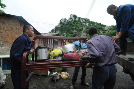 Chinese local residents collect and transfer their belongings after their residence was destroyed by rolling stones when a heavy rain hit Liuzhou City, southwest China&apos;s Guangxi Zhuang Autonomous Region, on May 20, 2009.