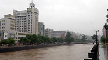 Flood water runs down a river in Chenzhou City, south China's Hunan Province, on May 20, 2009 after heavy rain swept across provinces in south China for the second day. Agricultural crops in some rural areas were flood by the unexpected summer flood.