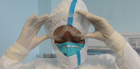 A nurse puts on a pair of goggles before entering the isolation ward at the Beijing Ditan Hospital in Beijing, capital of China, on May 20, 2009. The hospital is the appointed hospital for A/H1N1 flu patients in Beijing.