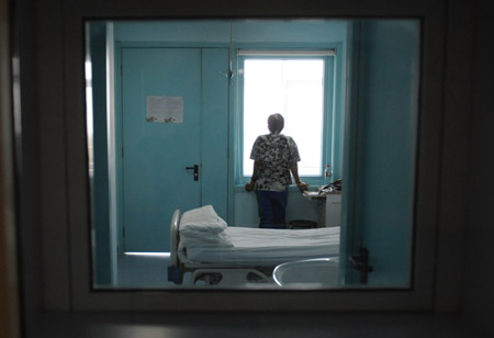 An isolated patient looks out of the window at the isolation ward at the Beijing Ditan Hospital in Beijing, capital of China, on May 20, 2009.