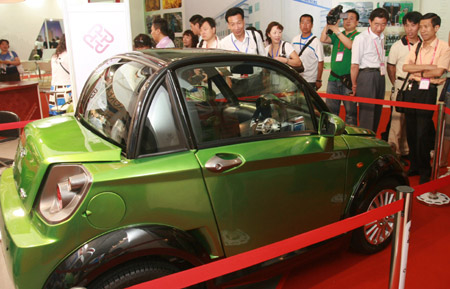 People visit a car dirven with electric power at the 12th Beijing International Science and Technology Exposition held in Beijing, on May 20, 2009. The mini car, which is designed by Hong Kong Polytechnic University, is able to run some one hundred kilometers once charged. 