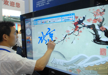 A Chinese visitor makes a test writing on an electron screen at the 12th Beijing International Science and Technology Exposition held in Beijing, on May 20, 2009. 