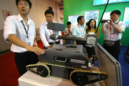 A Chinese staff shows off an explosive-proof robot at the 12th Beijing International Science and Technology Exposition held in Beijing, on May 20, 2009. 