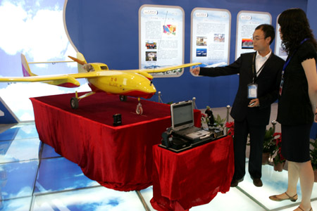 Chinese staff show off an automatic-piloted minisize airplane at the 12th Beijing International Science and Technology Exposition held in Beijing, on May 20, 2009.