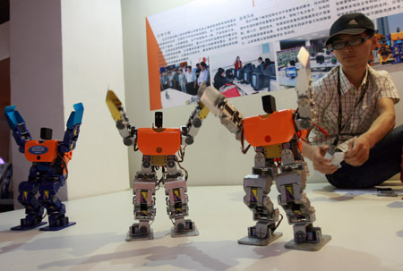 A Chinese staff shows off remot-controlled robots at the 12th Beijing International Science and Technology Exposition held in Beijing, on May 20, 2009. 