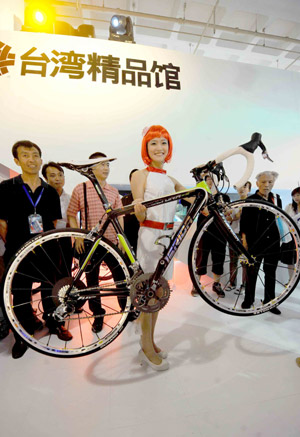 A model displays a carbon-fibre bicycle during the 12th China Beijing International High-Tech Expo in Beijing, capital of China, on May 20, 2009. The expo opened here Wednesday.