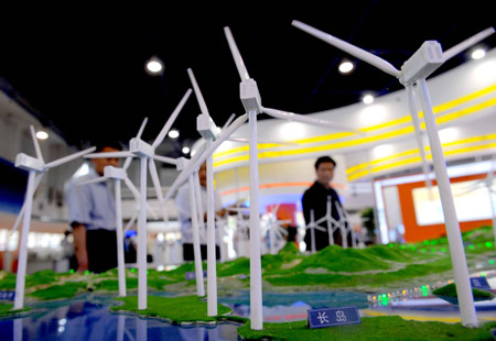 Visitors look at a model of a wind power station during the 12th China Beijing International High-Tech Expo in Beijing, capital of China, on May 20, 2009.