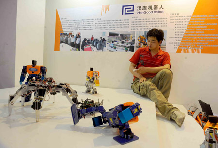 A staff member operates robots for university teaching during the 12th China Beijing International High-Tech Expo in Beijing, capital of China, on May 20, 2009. The expo opened here Wednesday. 