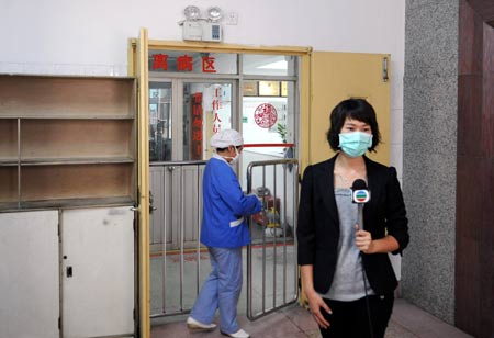 A reporter works in the No. 8 People's Hospital in Guangzhou, south China's Guangdong Province, on May 22, 2009. The Health authorities in south China's Guangdong Province released a confirmed A/H1N1 flu-inflicted people whose surname is Yang. He is China's fourth confirmed A/H1N1 flu case till Friday. 