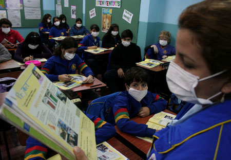 Teachers and pupils have their class while wearing masks to prevent the spread of A/H1N1 flu virus at a school in Asuncion, capital of Paraguay, on May 29, 2009. The Paraguay health authorities confirmed on May 28 that there were five cases of the A/H1N1 influenza in the country. 