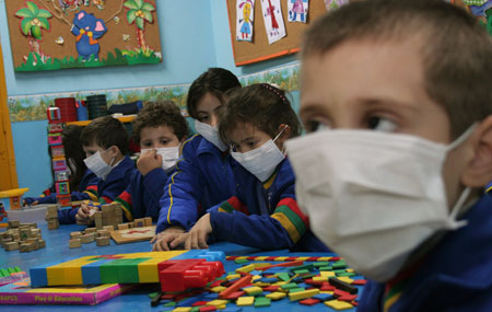 Pupils have their class while wearing masks to prevent the spread of A/H1N1 flu at a school in Asuncion, capital of Paraguay, on May 29, 2009. The Paraguay health authorities confirmed on May 28 that there were five cases of the A/H1N1 influenza in the country.