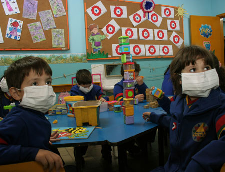 Pupils have their class while wearing masks to prevent the spread of A/H1N1 flu at a school in Asuncion, capital of Paraguay, on May 29, 2009. The Paraguay health authorities confirmed on May 28 that there were five cases of the A/H1N1 influenza in the country.