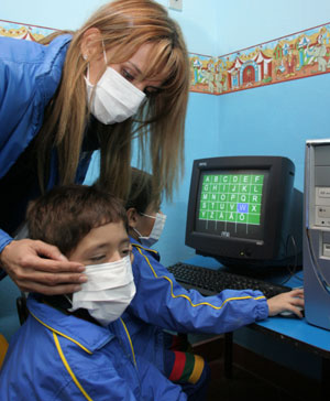 A teacher helps her pupil to adjust the mask to prevent the spread of A/H1N1 flu at a school in Asuncion, capital of Paraguay, on May 29, 2009. The Paraguay health authorities confirmed on May 28 that there were five cases of the A/H1N1 influenza in the country.