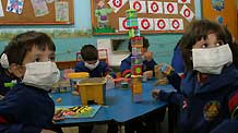 Pupils have their class while wearing masks to prevent the spread of A/H1N1 flu at a school in Asuncion, capital of Paraguay, on May 29, 2009. The Paraguay health authorities confirmed on May 28 that there were five cases of the A/H1N1 influenza in the country.