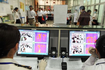 Staff members check temperatures of passengers at the Maweigang dock in Fuzhou, capital of southeast China's Fujian Province, on May 30, 2009. The third case of A/H1N1 in Fujian was confirmed in Fuzhou on May 29. 