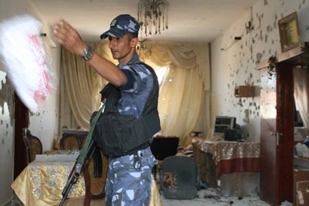 A member of the Palestinian National Authority (PNA) security forces inspects the scene of a clash between the PNA forces and Hamas gunmen in the West Bank town of Qalqilya, on May 31, 2009. 