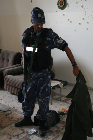 A member of the Palestinian National Authority (PNA) security forces inspects the scene of a clash between the PNA forces and Hamas gunmen in the West Bank town of Qalqilya, on May 31, 2009.